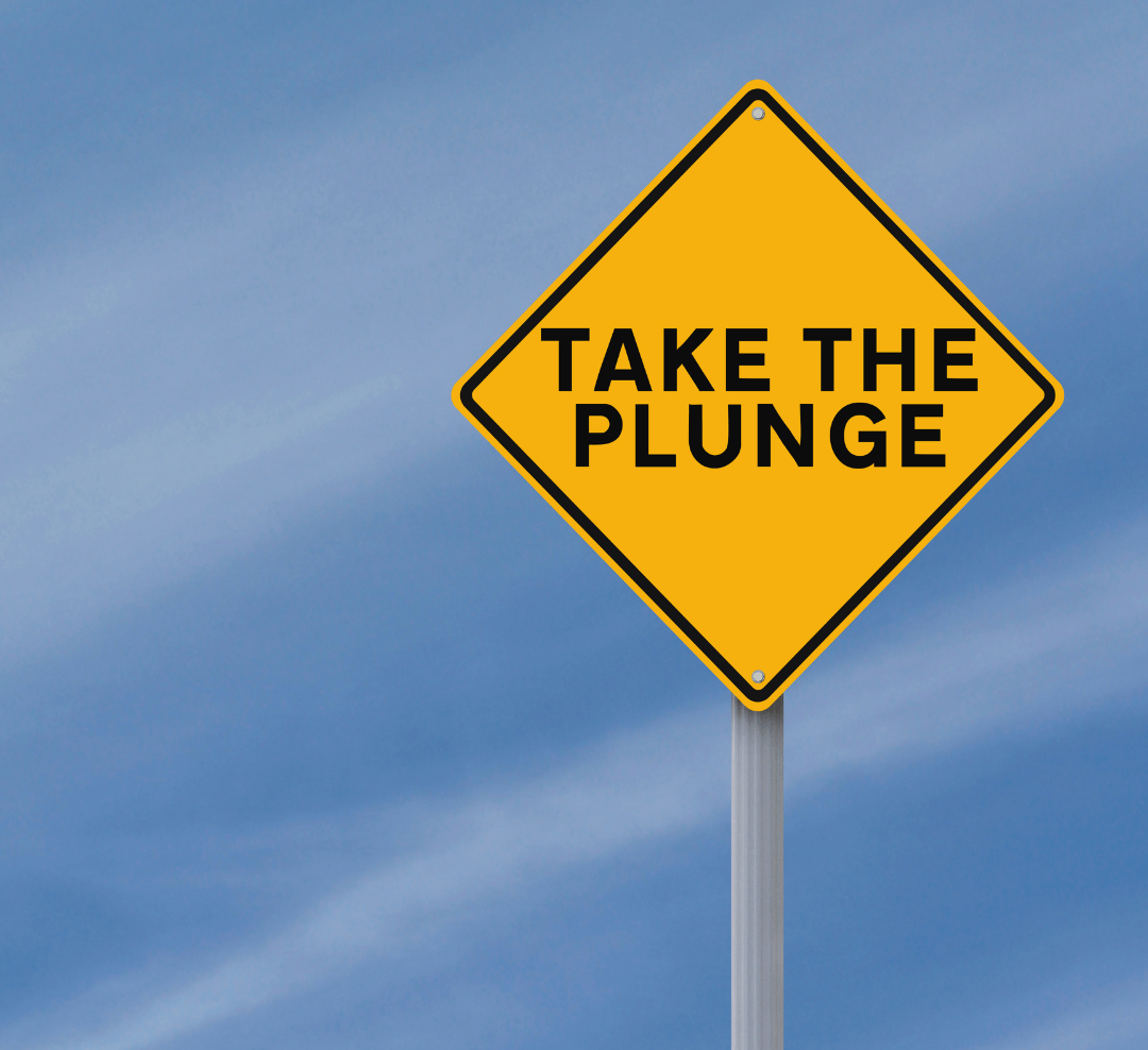 A bright yellow sign with the words Take the Plunge set against a clear blue sky.