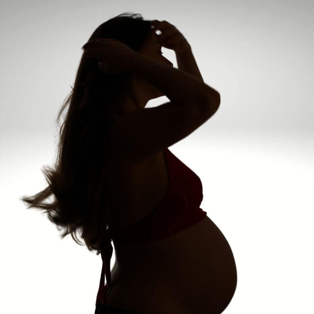 Black and white side silhouette of a pregnant woman